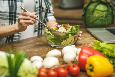 Dizüstü bilgisayar mutfak masasında ve aşçı kız. Yemek blogcusu kavramı. Yakın plan.