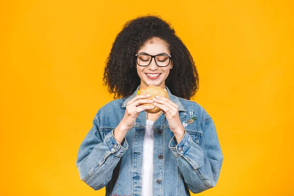 Afroamericana Joven Negra Comiendo Hamburguesa Aislada Sobre Fondo Amarillo — Foto de Stock