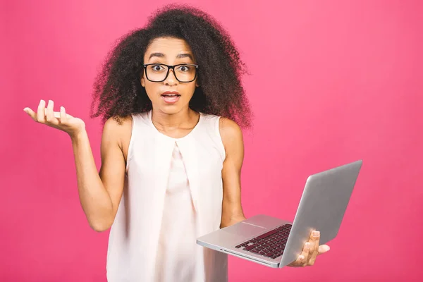 Shocked amazed african american black business or student woman, posing isolated on pink background. Mock up copy space. Working on laptop pc computer.