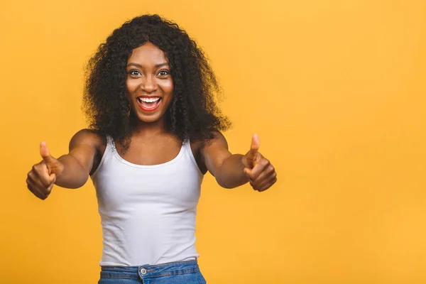 Young African American black woman isolated on yellow background giving a thumbs up gesture.