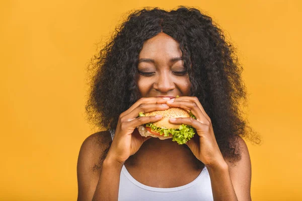 Αφρικανική Αμερικανική Μαύρη Όμορφη Νεαρή Γυναίκα Τρώει Χάμπουργκερ Απομονωμένη Κίτρινο — Φωτογραφία Αρχείου