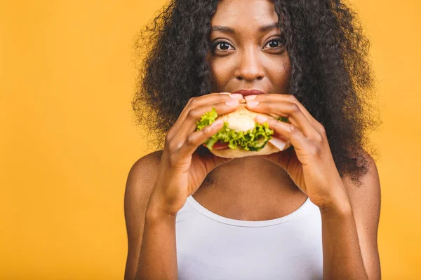 Afrikai Amerikai Fekete Gyönyörű Fiatal Eszik Hamburger Elszigetelt Sárga Háttér — Stock Fotó