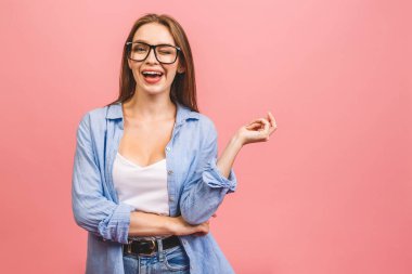 Pembe duvar arkasında yalnız poz veren mutlu genç iş kadını görüntüsü.