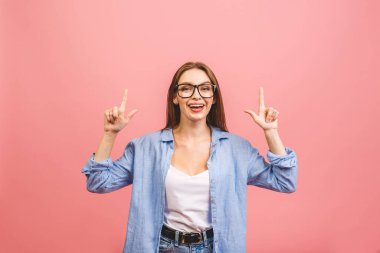 Pembe arka planı işaret eden güzel genç bir kadının portresi..