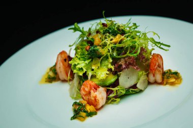 Kaplan karidesli salata, beyaz tabakta armut ve avokado.