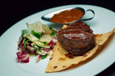 Armutlu dana biftek ve soslu mavi peynir salatası.