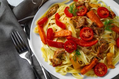 Kızarmış et, havuç, dolma biber, dereotu domatesli, kumaşla süslenmiş. Sebzeli makarna. Yukarıdan görüntüle.