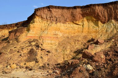 Yatay kil katmanlı jeolojik bölüm ve çeşitli renklerde kum.