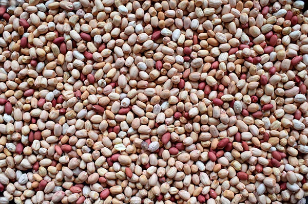 Peanuts of two varieties in a flat bowl, can be used as a background.