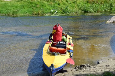 Durak sırasında küçük bir nehrin sahilinde yüklü bir kano..