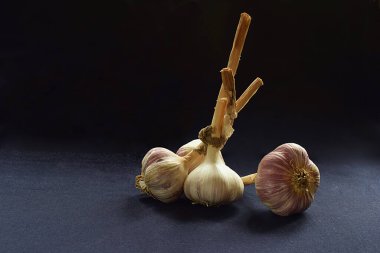 Bir demet sarımsak ve yakın plan çekimde ayrı bir soğan..