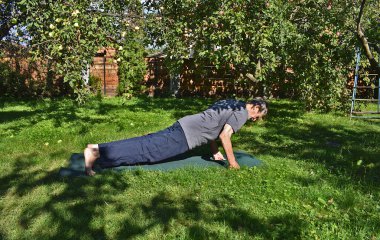 76 yaşında bir adam formda kalmak için bahçede şınav çeker..