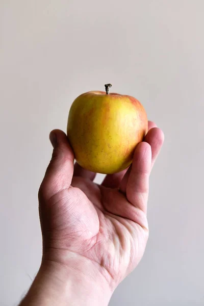 Sosteniendo Una Manzana Una Mano Blanca Masculina Desde Abajo Aislada — Foto de Stock