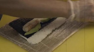 Aşçı soya soslu suşi, wasabi ve fesleğen yapıyor. Geleneksel olarak orta taneli beyaz pirinçle yapılır. Japon sopaları. Restoran menüsü resmi.
