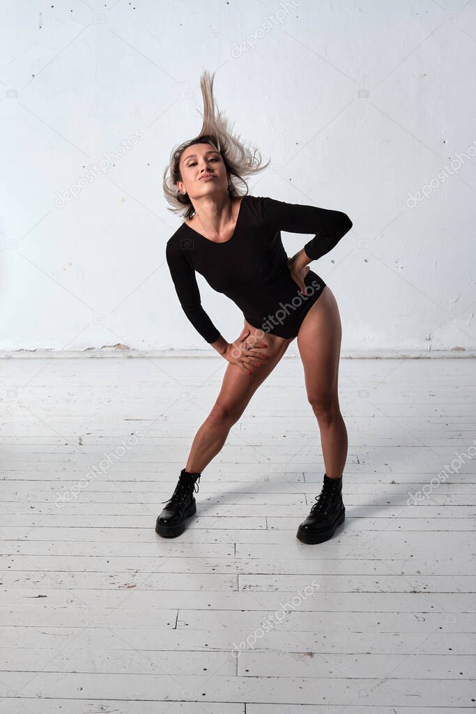 Young adult white woman dressed in body dancing in the studio on wall background. Concept of dancing people.