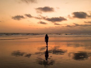 Sahilde güzel bir kadının silueti.