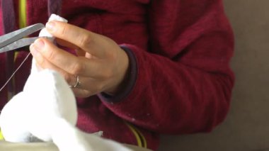 Dişi eller oyuncak ayı diker. Yumuşak el yapımı oyuncaklar yaratmak. İğne ve bir kadının elinde iplik - o yumuşak bir oyuncak ayrıntıları nı diker
