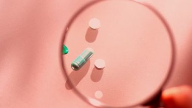 Laboratuvar testleri. Masanın üzerinde yatan hapları yakından inceliyorum. İlaçlarda yakın çekim.