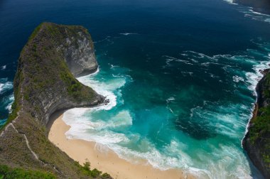 Kelingking plajı (Manta körfezi) Bali, Nusa Penida 'da bulunan bir T-Rex uçurumu. Sarp bir uçurum ve burunla çevrili turkuaz sulara sahip beyaz kumlu sahil. Tepenin tepesinden bak..