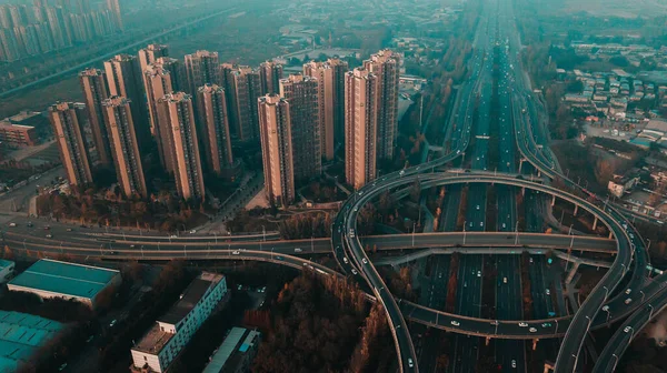 Huge leveled up elevated road traffic junction next to the tall skyscrapers multi-storey residential buildings. Eastern part of Chengdu, Chenghua district. High level air pollution, unhealthy AQI.