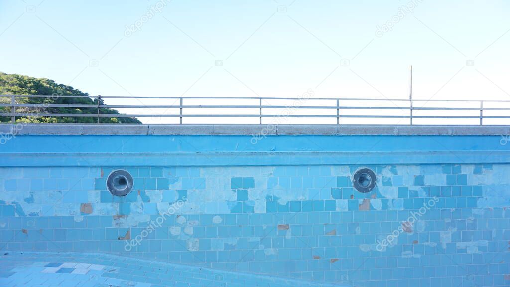 abandoned empty pool against blue sky background