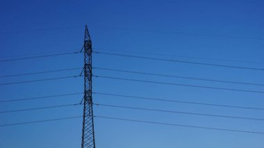 Mavi arkaplana karşı metal elektrik kulesi