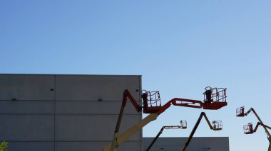 Mavi arkaplana karşı teleskopik vinçlerin silueti