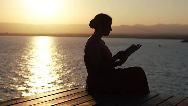 Silueta Niña Leyendo Cerca Del Mar —  Fotos de Stock