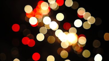 Dağınık kırmızı, beyaz ve altın renkli daireler, parlayan yıldızlarla dolu canlı bir gece gökyüzünü andıran karanlık arka planda parlıyor..