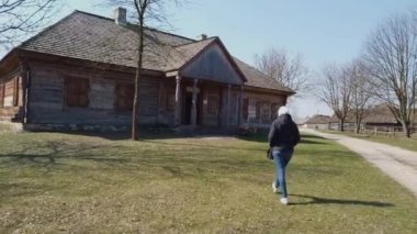 Kadın turist, eski bir Avrupa Kelt köyündeki ahşap bir eve gider.