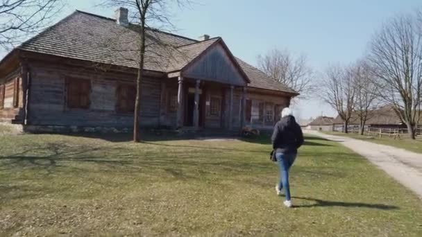 Női turista megy egy faházba egy régi európai kelta faluban — Stock videók