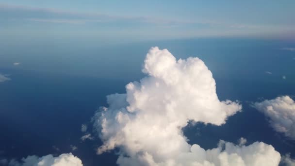 Beautiful aerial view at land and white fluffy clouds through window of flying plane. — Stock Video