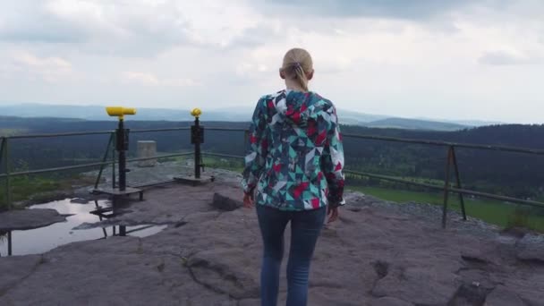 Kvinna promenader längs utsiktspunkten på toppen av ett berg. — Stockvideo