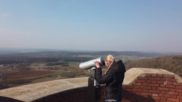 Atractivo viajero femenino usando binocular para mirar alrededor del valle cerca del antiguo castillo — Vídeo de stock