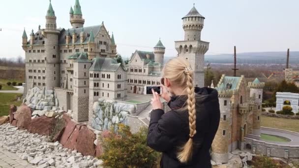 Donna fa foto camminare a piedi vicino a un modello in miniatura del vecchio castello Neuschwanstein, Germania. Parco delle Miniature. — Video Stock