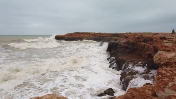 Långsam rörelse video av vågor bryta över stenar under en storm 4K — Stockvideo