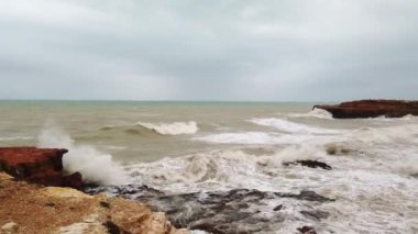 Parlak okyanus dalgaları, kaya dalgaları, kıyı kayalarına vuran dalgalar, köpüklü kayaları ezen dalgalar.