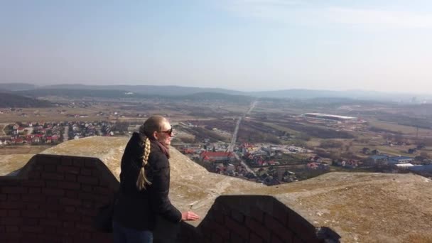 Viajante feminina atraente olhando em torno do vale perto do castelo velho — Vídeo de Stock