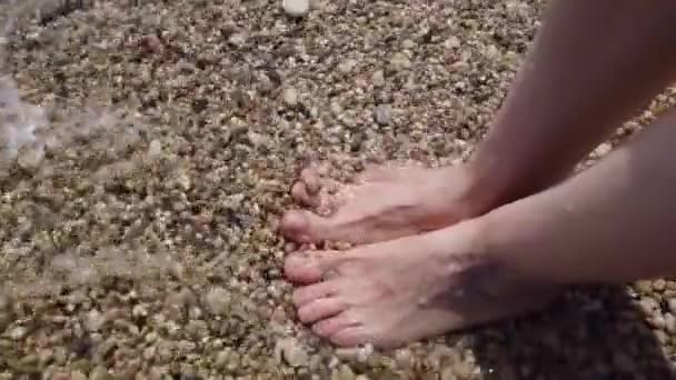 Морська вода миє жіночі ноги на пляжі — стокове відео