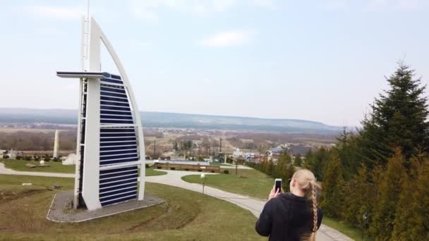 Femmina fa foto camminare a piedi vicino a un modello in miniatura del Burj Al Arab Jumeirah. Parco delle Miniature. — Video Stock