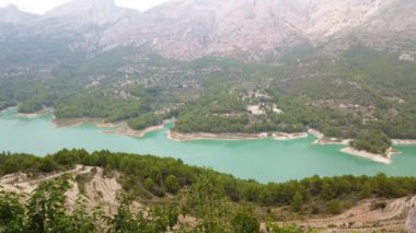 Turkuaz suyu ve yeşil ağacı olan dağ gölü..