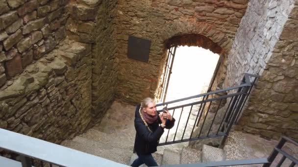 Una ragazza che cammina attraverso un vecchio castello e scattare foto — Video Stock