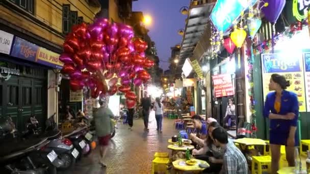 Escena callejera con gente en el restaurante en la noche en Hanoi, Vietnam . — Vídeos de Stock