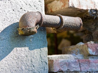Eski paslı su boruları duvar önünde