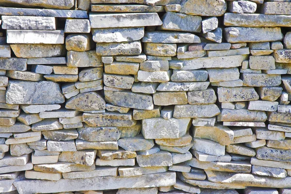 Stone wall built with blocks and marble slabs simply placed over one another