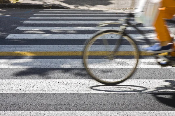 コピー スペースとぼかしのモーションで横断歩道上で自転車ライダー — ストック写真