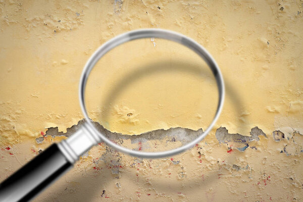 Damaged plaster wall - Concept image seen through a magnifying glass