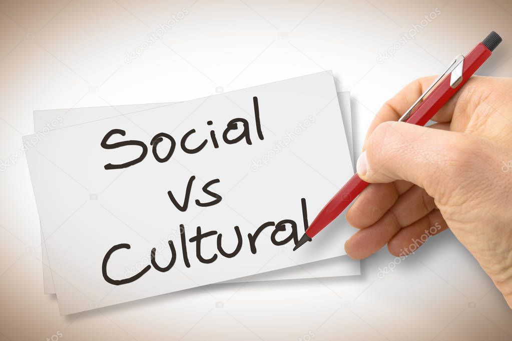 Hand writing Social Vs Cultural with a pencil on a blank sheet - concept image