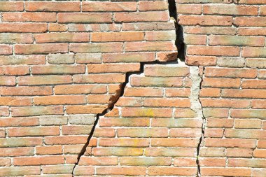 Old brick wall cracked and damaged - wall with diagonal crack clipart