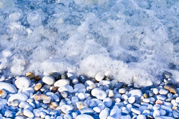 Pedras brancas arredondadas sob água fresca transparente — Fotografia de Stock